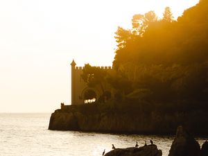 Preview wallpaper castle, coast, cliffs, sea, sunset