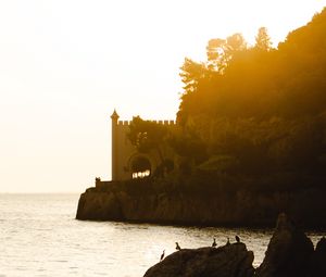 Preview wallpaper castle, coast, cliffs, sea, sunset