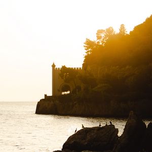 Preview wallpaper castle, coast, cliffs, sea, sunset