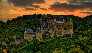 Preview wallpaper castle, mountain, trees, forest, hill, clouds, sunset, dark