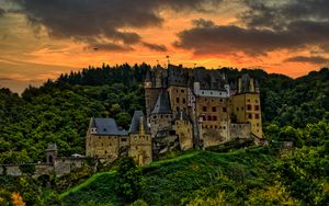 Preview wallpaper castle, mountain, trees, forest, hill, clouds, sunset, dark