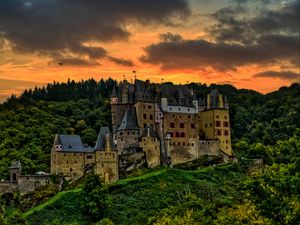 Preview wallpaper castle, mountain, trees, forest, hill, clouds, sunset, dark