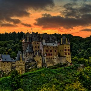 Preview wallpaper castle, mountain, trees, forest, hill, clouds, sunset, dark