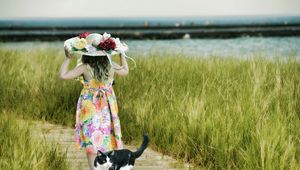 Preview wallpaper cat, child, hat, field, grass