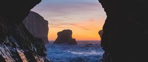 Preview wallpaper cave, rocks, sea, sunset