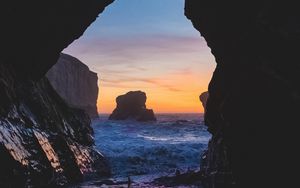 Preview wallpaper cave, rocks, sea, sunset