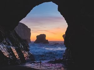 Preview wallpaper cave, rocks, sea, sunset