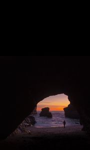 Preview wallpaper cave, rocks, silhouette, water, sunset