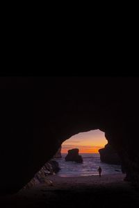 Preview wallpaper cave, rocks, silhouette, water, sunset