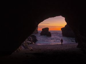 Preview wallpaper cave, rocks, silhouette, water, sunset