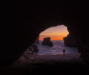 Preview wallpaper cave, rocks, silhouette, water, sunset