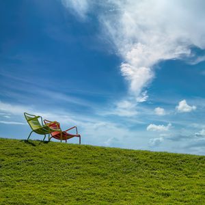 Preview wallpaper chairs, grass, hill, sky, clouds