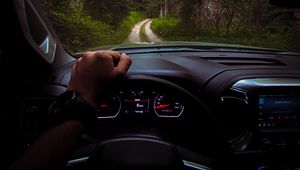 Preview wallpaper chevrolet, car, steering wheel, hand, forest