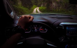 Preview wallpaper chevrolet, car, steering wheel, hand, forest