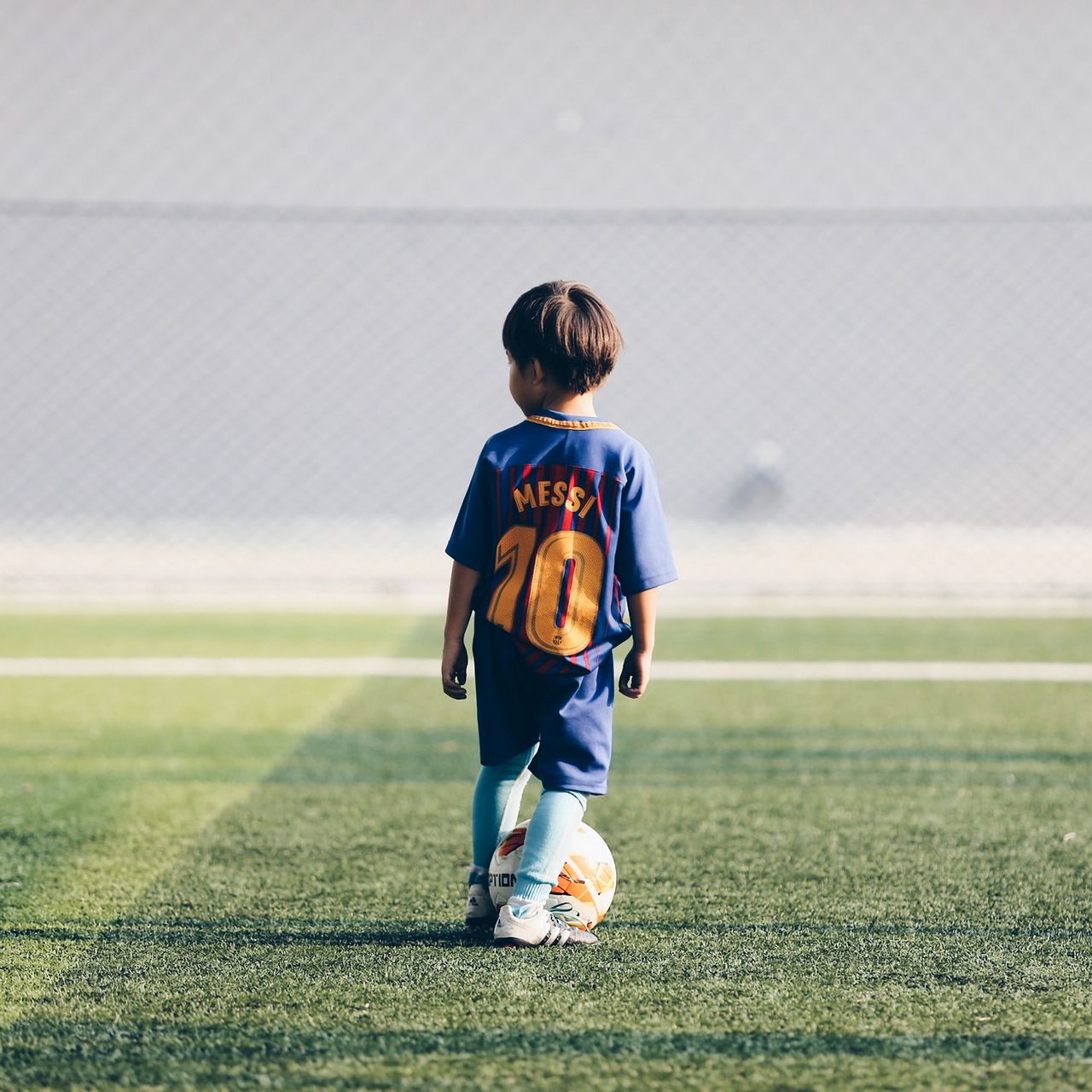 Download wallpaper 1280x1280 child, football player, football, football  field, ball, lawn ipad, ipad 2, ipad mini for parallax hd background