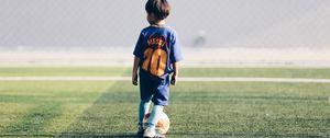 Preview wallpaper child, football player, football, football field, ball, lawn