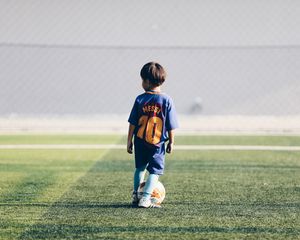 Preview wallpaper child, football player, football, football field, ball, lawn