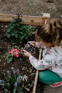 Preview wallpaper child, photographer, girl, flower bed, flowers, interest, hobby