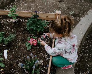 Preview wallpaper child, photographer, girl, flower bed, flowers, interest, hobby