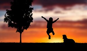 Preview wallpaper child, silhouette, jump, happiness, dog, sunset