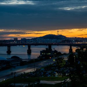 Preview wallpaper city, bridge, river, road, hill, evening, twilight