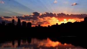 Preview wallpaper city, building, sky, sunset, clouds, river, sea