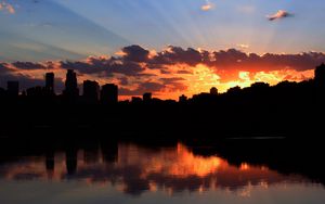 Preview wallpaper city, building, sky, sunset, clouds, river, sea