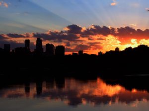 Preview wallpaper city, building, sky, sunset, clouds, river, sea