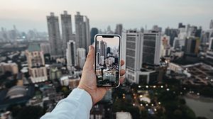Preview wallpaper city, buildings, aerial view, hand, phone, overview
