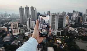 Preview wallpaper city, buildings, aerial view, hand, phone, overview