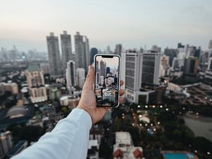 Preview wallpaper city, buildings, aerial view, hand, phone, overview