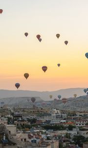 Preview wallpaper city, buildings, balloons, sky, sunset