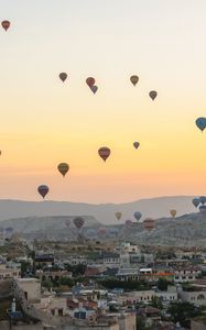 Preview wallpaper city, buildings, balloons, sky, sunset