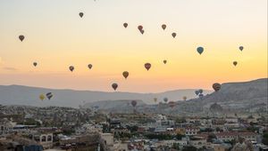 Preview wallpaper city, buildings, balloons, sky, sunset