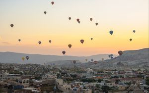 Preview wallpaper city, buildings, balloons, sky, sunset