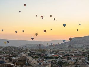 Preview wallpaper city, buildings, balloons, sky, sunset