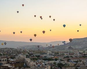 Preview wallpaper city, buildings, balloons, sky, sunset