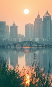 Preview wallpaper city, buildings, bridge, lake, sunset, sun