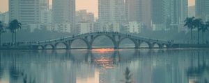 Preview wallpaper city, buildings, bridge, lake, sunset, sun