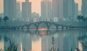 Preview wallpaper city, buildings, bridge, lake, sunset, sun