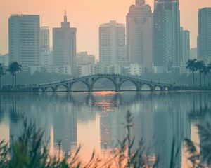 Preview wallpaper city, buildings, bridge, lake, sunset, sun