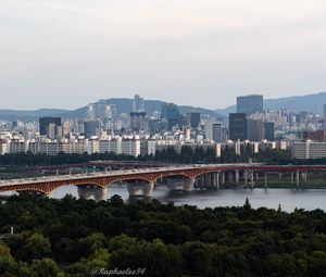 Preview wallpaper city, buildings, bridge, trees, river, aerial view