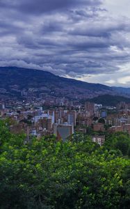 Preview wallpaper city, buildings, cityscape, aerial view, trees, mountains