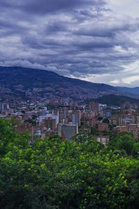 Preview wallpaper city, buildings, cityscape, aerial view, trees, mountains