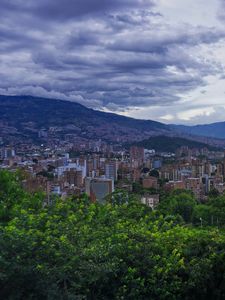 Preview wallpaper city, buildings, cityscape, aerial view, trees, mountains