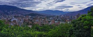 Preview wallpaper city, buildings, cityscape, aerial view, trees, mountains