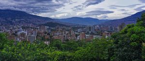 Preview wallpaper city, buildings, cityscape, aerial view, trees, mountains