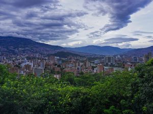 Preview wallpaper city, buildings, cityscape, aerial view, trees, mountains