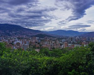 Preview wallpaper city, buildings, cityscape, aerial view, trees, mountains