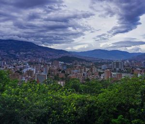 Preview wallpaper city, buildings, cityscape, aerial view, trees, mountains